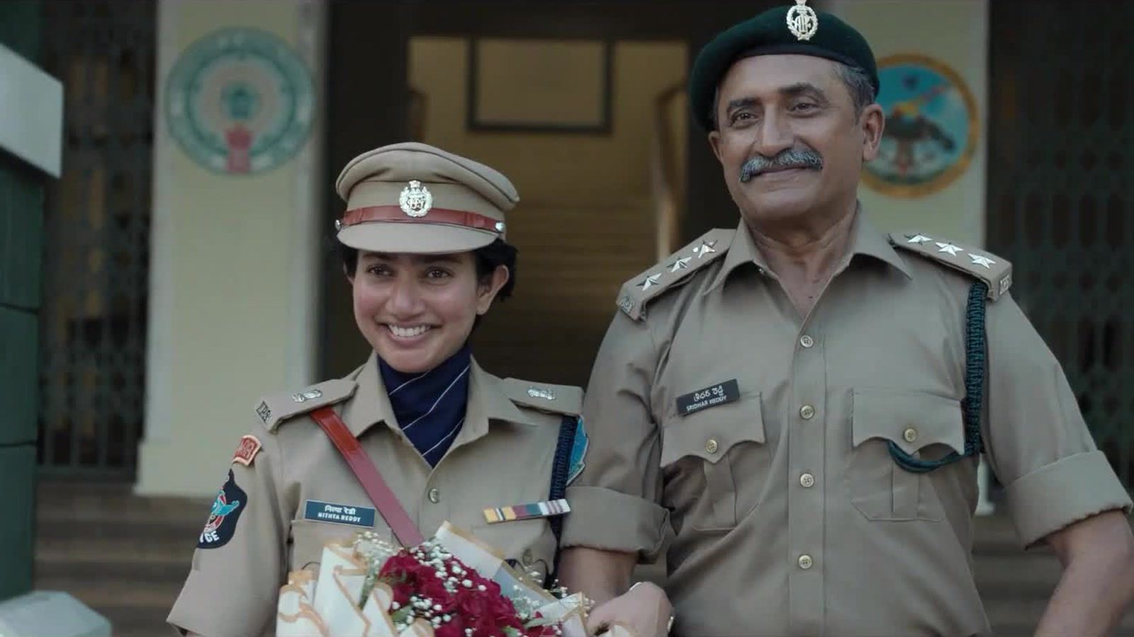 Sai Pallavi as police officer Nithya Reddy, smiling in uniform with a bouquet beside a senior officer, in the OM glimpse