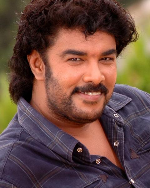 Sundar C with curly hair and a moustache in a dark shirt, half-length portrait