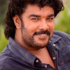 Sundar C with curly hair and a moustache in a dark shirt, half-length portrait