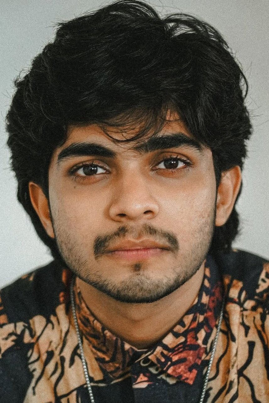 Naslen with tousled hair in a printed shirt, close-up portrait