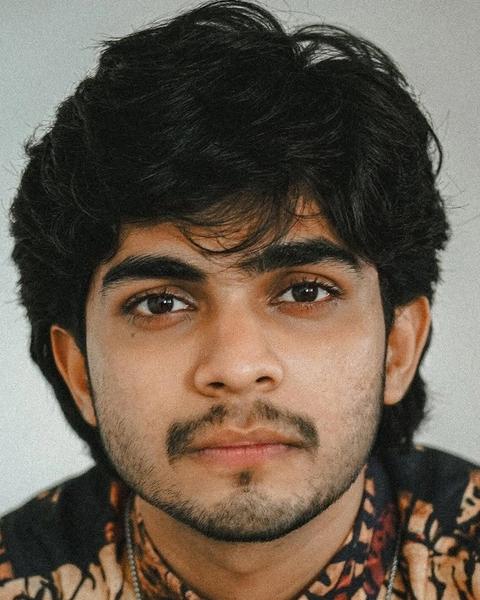 Naslen with tousled hair in a printed shirt, close-up portrait
