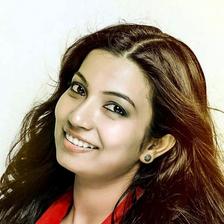 Sreeja Das smiling in a red top, close-up portrait