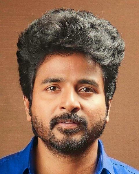 Sivakarthikeyan with a beard in a bright blue shirt, portrait