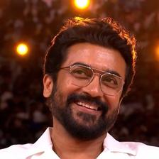 Suriya smiling in glasses and a white shirt at the Retro audio launch