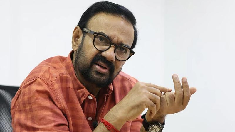 Actor Maniyanpilla Raju in glasses and an orange checked shirt, speaking