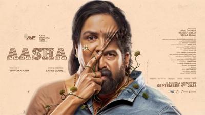 Aasha still showing Urvashi and Joju George's faces split by a thorny branch
