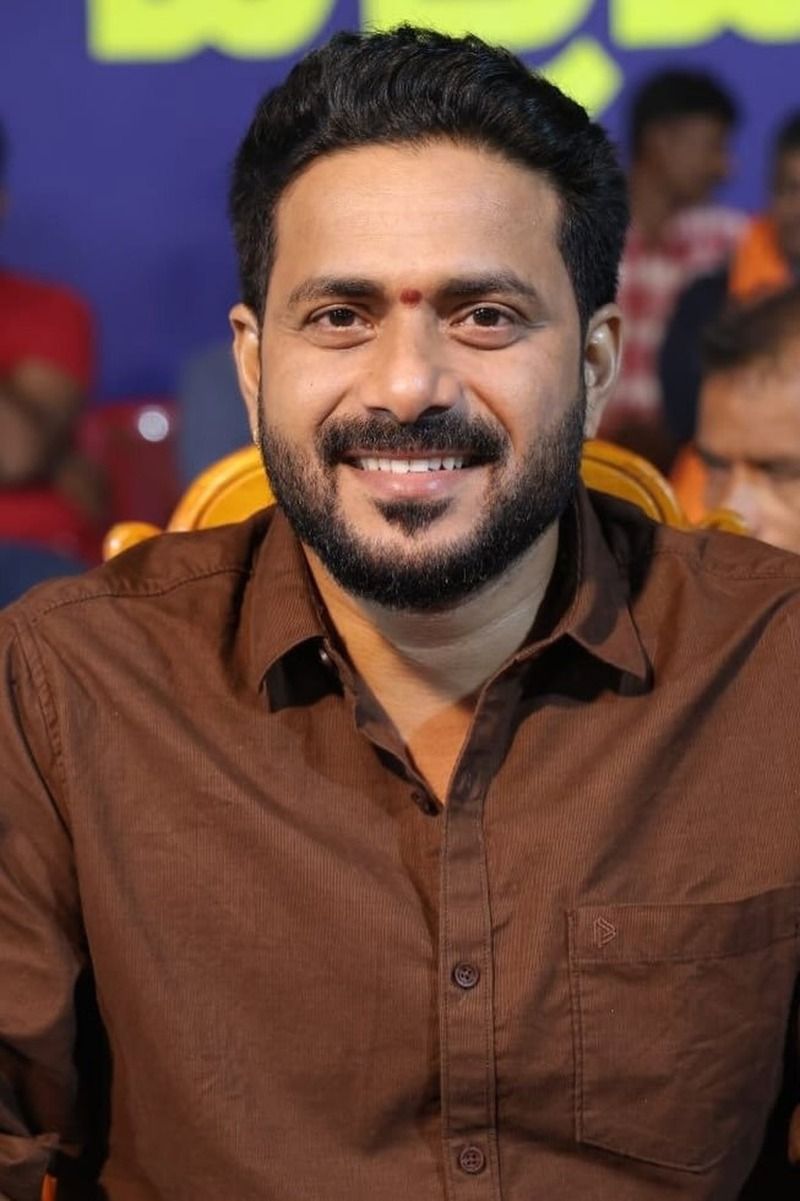 J. P. Thuminad smiling in a brown shirt at an indoor event