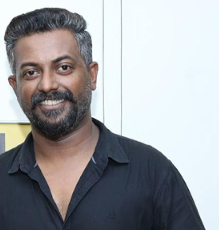 Binu Pappu in a black shirt against a light wall, portrait