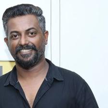 Binu Pappu in a black shirt against a light wall, portrait