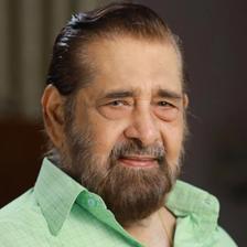 Madhu in a pale green checked shirt, smiling, half-length portrait