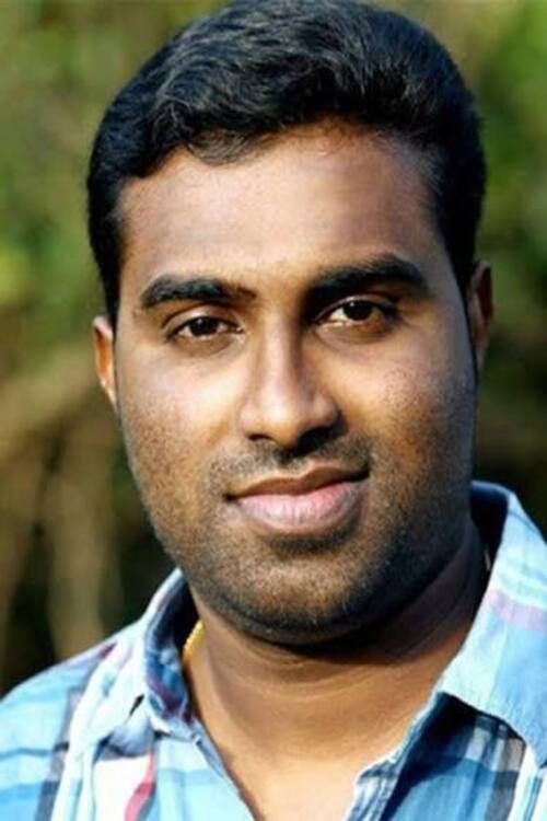 Jinu Abraham in a checked shirt outdoors, close-up portrait