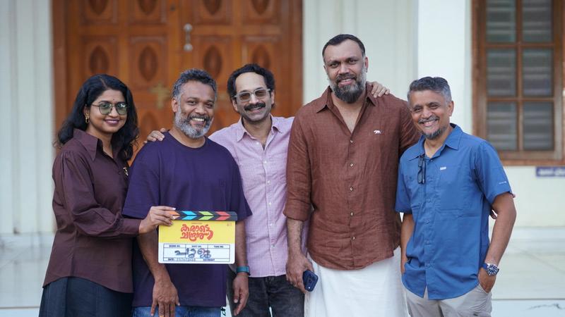 Fahadh Faasil holding the Karate Chandran clapboard with the team at the film's pooja