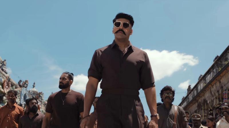 Arya in sunglasses walking ahead of a crowd in the World of Vettuvam video