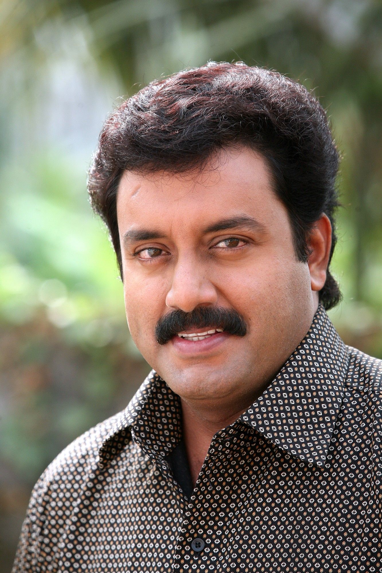 Suresh Krishna with a moustache in a checked shirt, portrait
