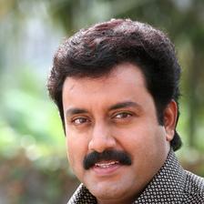 Suresh Krishna with a moustache in a checked shirt, portrait