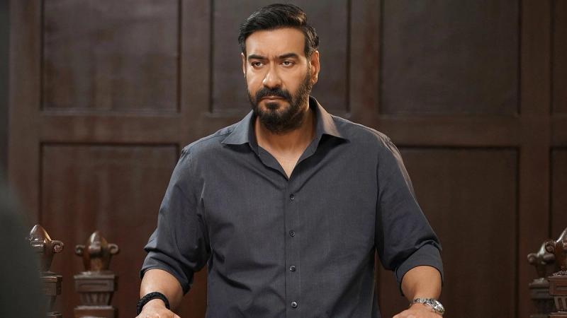 Ajay Devgn as Vijay Salgaonkar standing in a grey shirt in Drishyam: The Conclusion