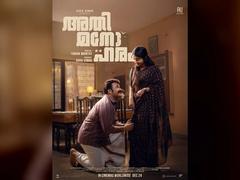 Mohanlal kneels beside Meera Jasmine in a home setting on the official Athimanoharam poster