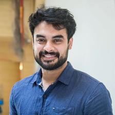 Tovino Thomas with a beard in a blue shirt, portrait
