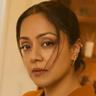 Jyothika in a mustard-yellow blazer with her hair tied back, looking at the camera