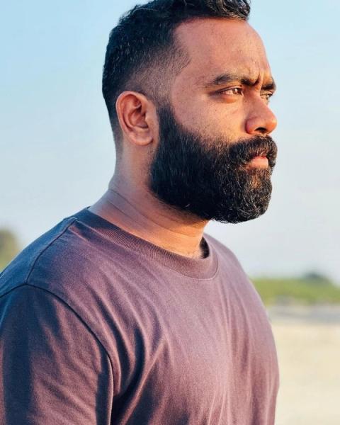 Sajin Gopu with a beard in a T-shirt, outdoor side profile