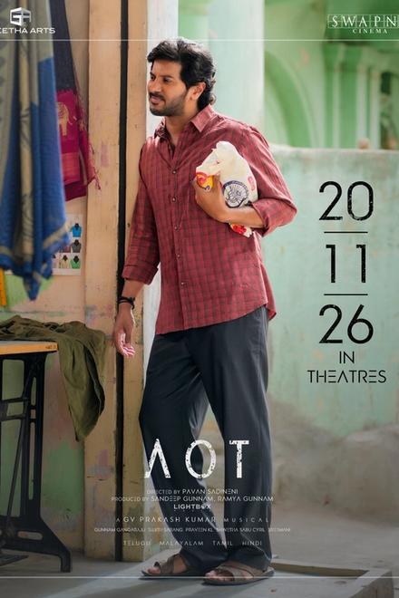 Aakasamlo Oka Tara poster showing Dulquer Salmaan in a red checked shirt beside a tailoring shop, with the 20.11.26 release date