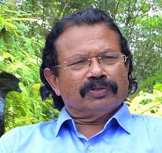 Tomichan Mulakuppadam in glasses with a moustache outdoors