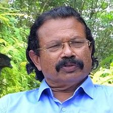 Tomichan Mulakuppadam in glasses with a moustache outdoors
