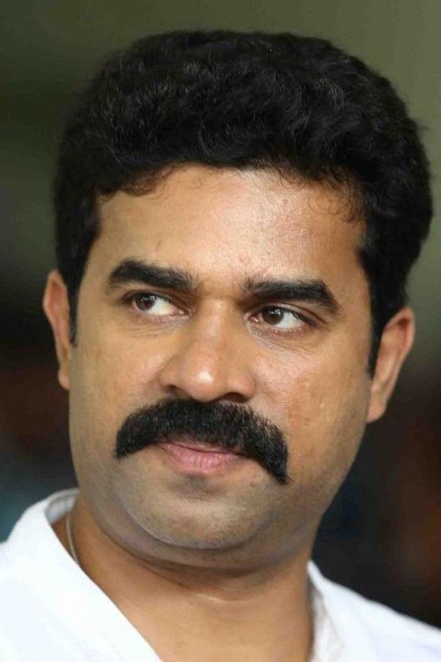 Vijay Babu with a thick moustache in a white shirt, portrait