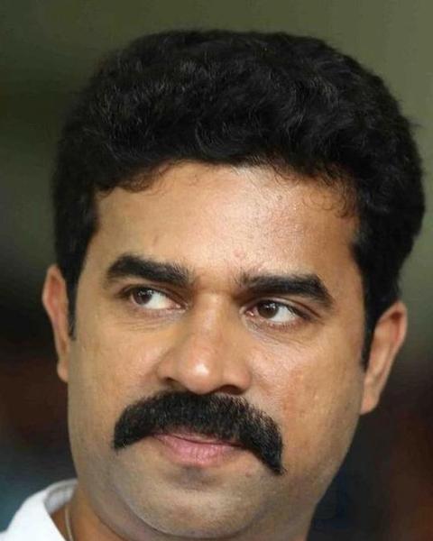 Vijay Babu with a thick moustache in a white shirt, portrait