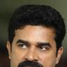 Vijay Babu with a thick moustache in a white shirt, portrait