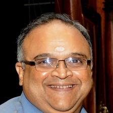 Mohan Raman smiling in glasses and a blue shirt, portrait