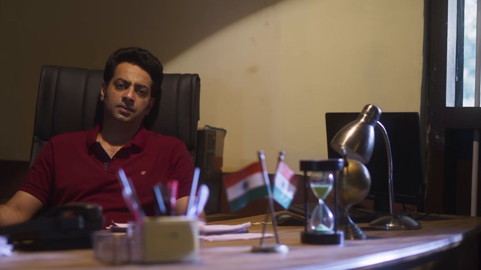 Saiju Kurup as a police officer at his desk in The Third Murder trailer
