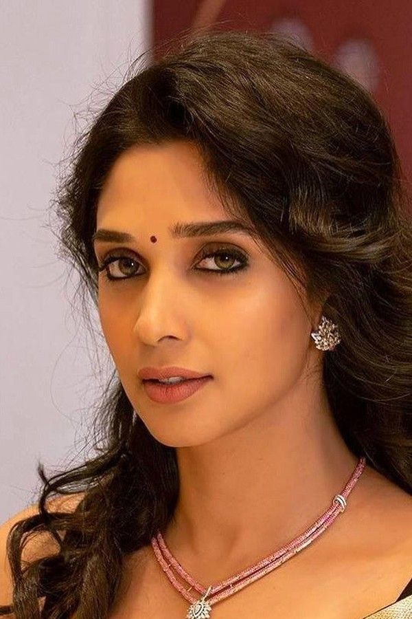 Nyla Usha with long hair and a pendant necklace, portrait