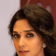 Nyla Usha with long hair and a pendant necklace, portrait