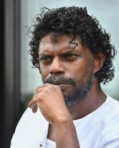 Vinayakan with curly hair, hand on chin, close-up portrait