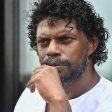 Vinayakan with curly hair, hand on chin, close-up portrait