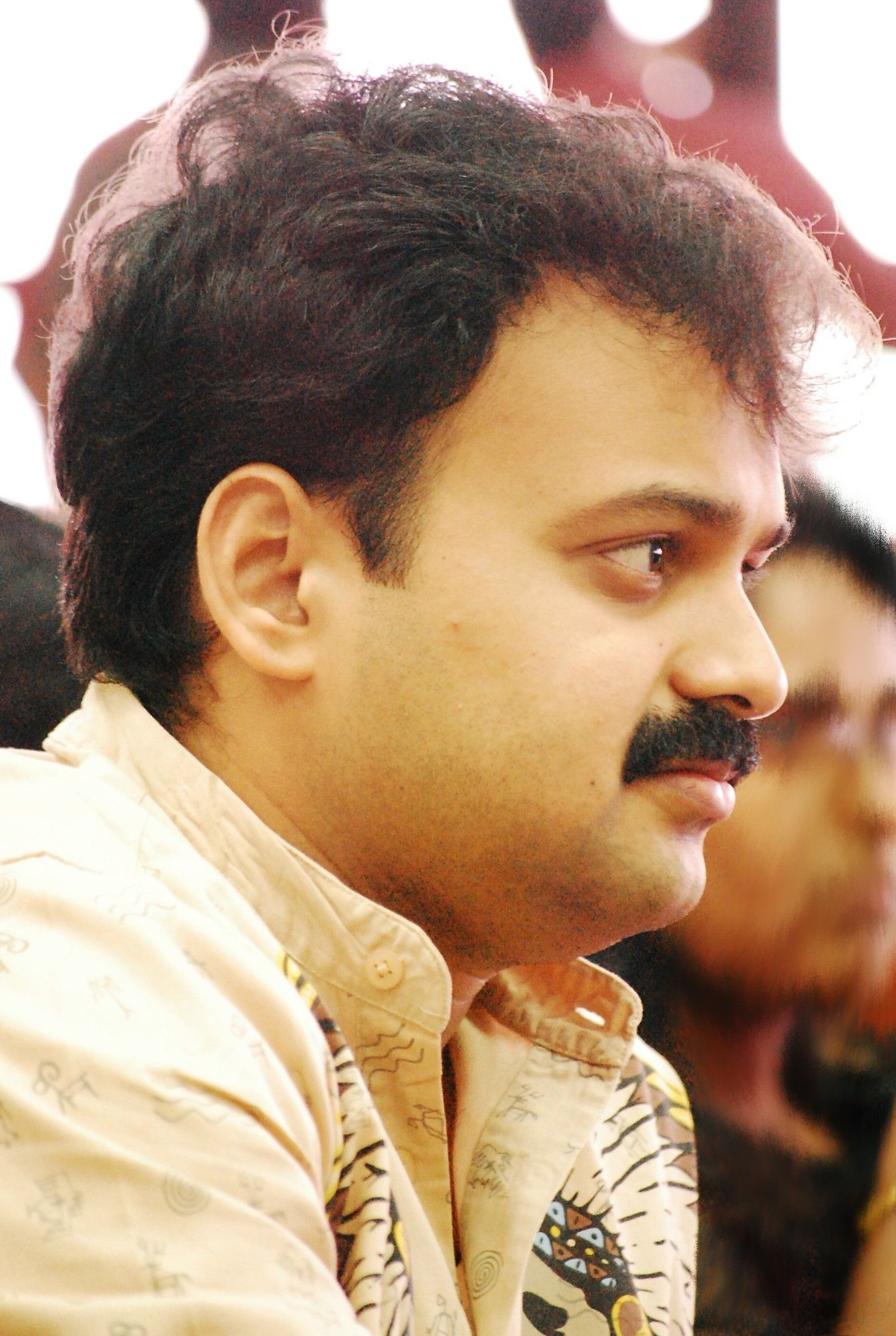 Kunchacko Boban with a moustache looking to the side, close-up portrait