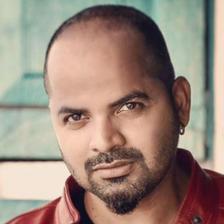 Vinay Forrt in a red jacket over a black T-shirt, half-length portrait