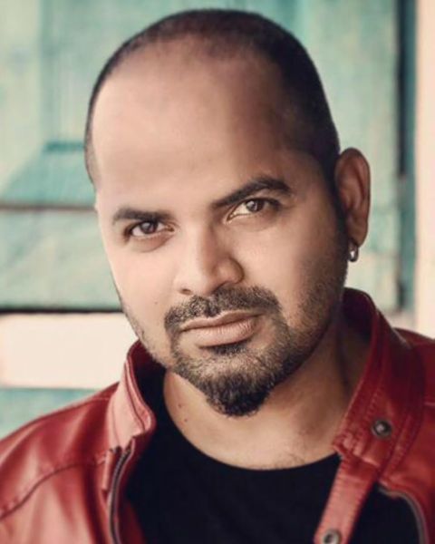 Vinay Forrt in a red jacket over a black T-shirt, half-length portrait
