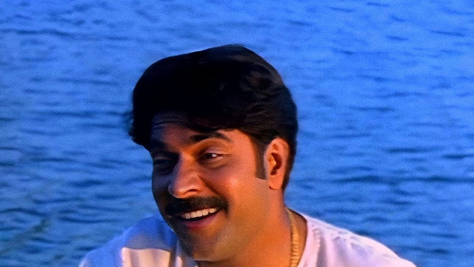 Mammootty smiling by the backwaters as Shankar Das in Kamal's 1996 film Azhakiya Ravanan