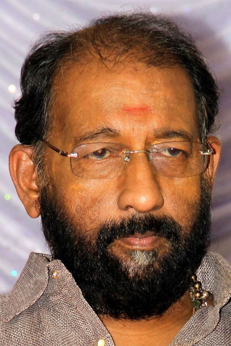 Nedumudi Venu with glasses and a grey beard, close-up portrait