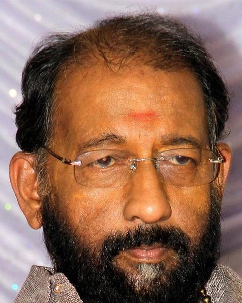 Nedumudi Venu with glasses and a grey beard, close-up portrait