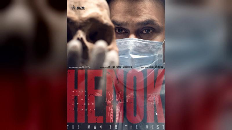 Dileep in a surgical mask with a skull in the foreground on the Henok The Man in the Mist first look poster