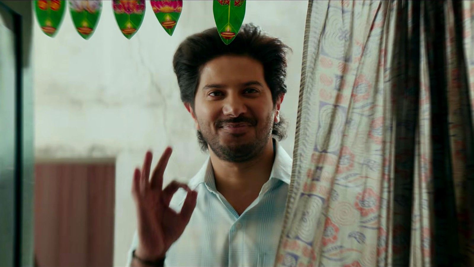 Dulquer Salmaan smiles and makes an OK sign in the Aakasamlo Oka Tara teaser
