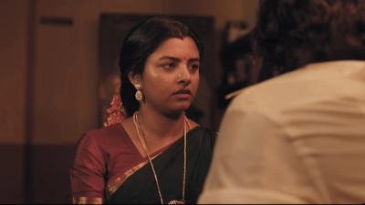 Baththa still of a woman in a saree standing in a dim room