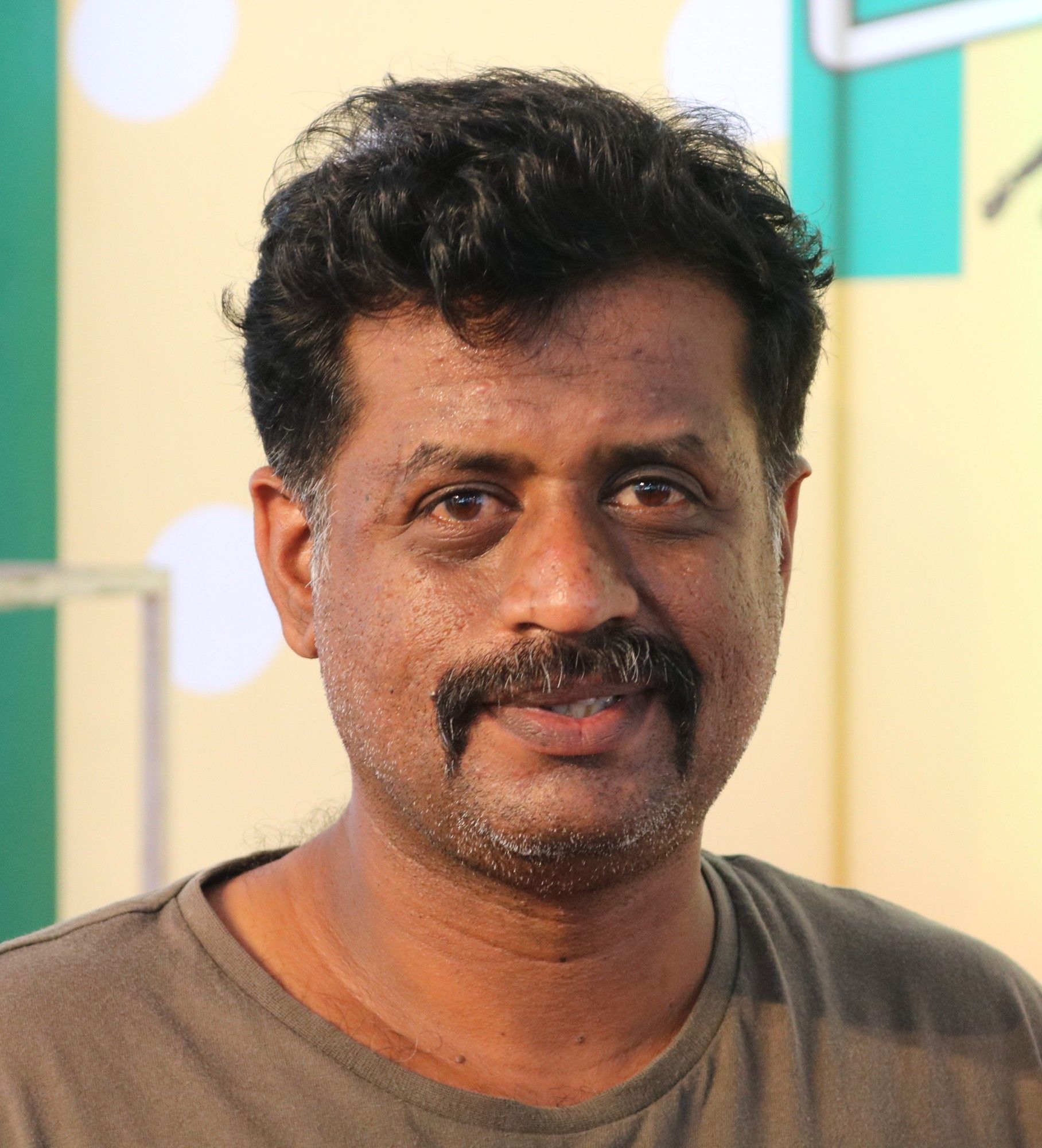 Jeo Baby with a moustache in a grey T-shirt, close-up portrait