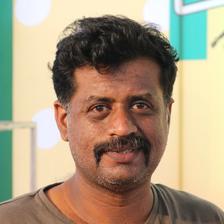 Jeo Baby with a moustache in a grey T-shirt, close-up portrait