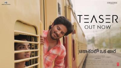 Dulquer Salmaan leans out of a train door as Satvika Veeravalli looks out of the window in the Aakasamlo Oka Tara teaser banner