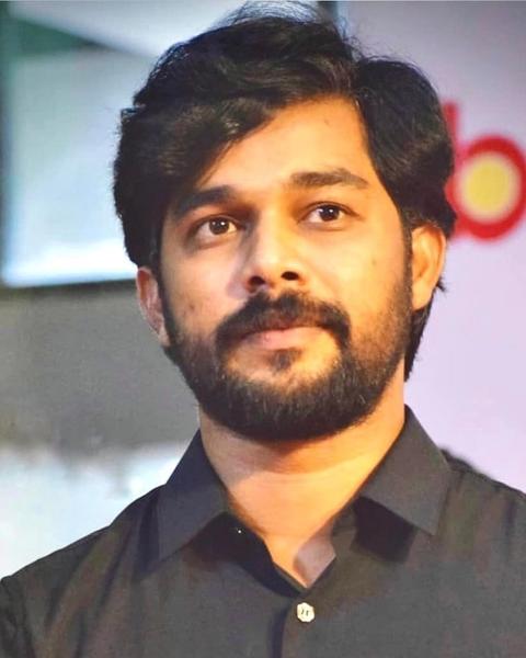 Sharafudheen with a beard in a black shirt, portrait