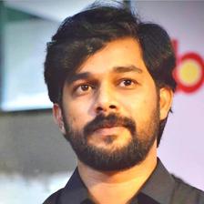 Sharafudheen with a beard in a black shirt, portrait